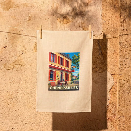 Torchon souvenir de la ville de Chénérailles avec une illustration stylisée d'une rue typique.