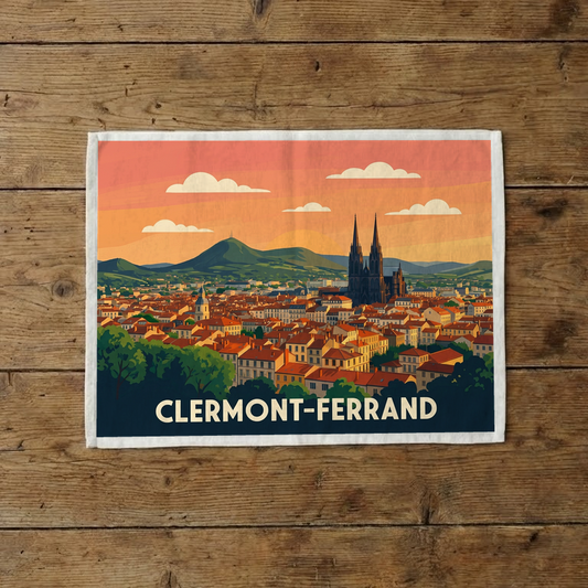Torchon souvenir de la ville de Clermont-Ferrand orné d'une illustration stylisée de son paysage urbain et de ses montagnes.