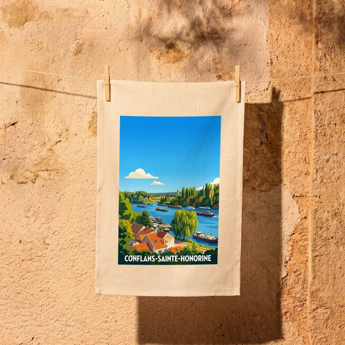Torchon souvenir de la ville de Conflans-Sainte-Honorine avec une illustration stylisée d'un paysage fluvial.