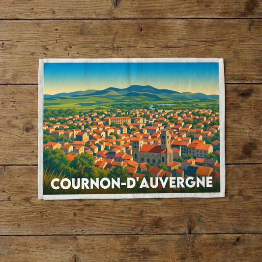 Torchon souvenir de la ville de Cournon-d'Auvergne avec une illustration stylisée et colorée.