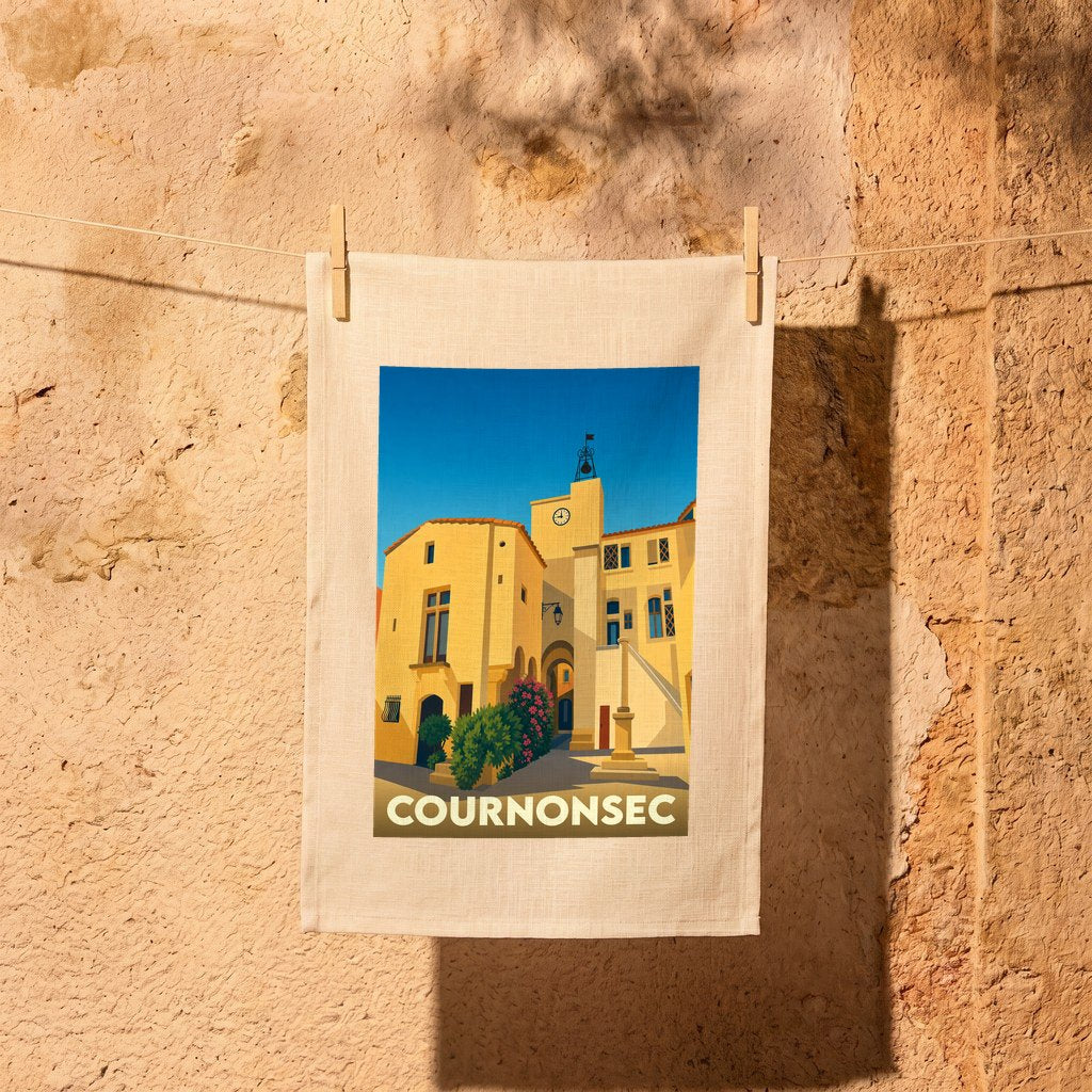 Torchon souvenir de la ville de Cournonsec orné d'une illustration stylisée du village sous un ciel bleu.
