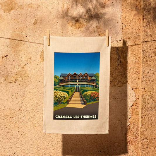 Torchon souvenir de la ville de Cransac-les-Thermes avec une illustration stylisée de ses thermes.
