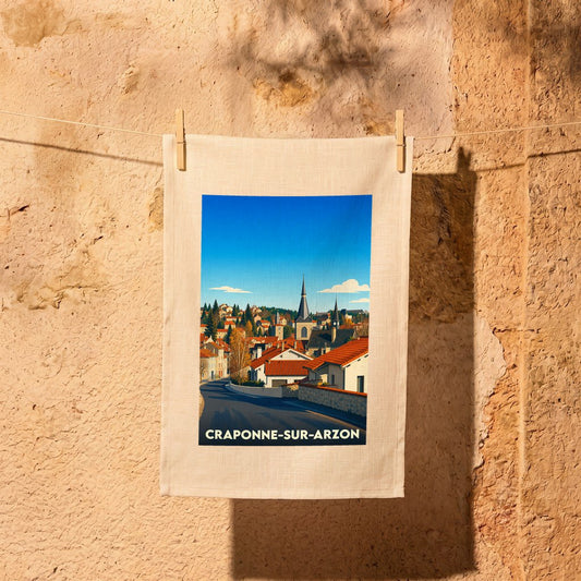 Torchon souvenir de la ville de Craponne-sur-Arzon avec une illustration stylisée d'un paysage urbain.