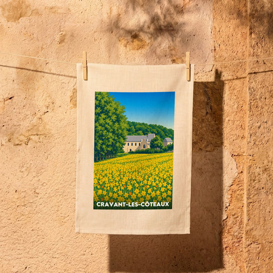 Torchon souvenir de la ville de Cravant-les-Côteaux avec une illustration stylisée d'un champ de fleurs jaunes et de son église.