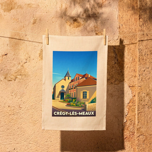 Torchon souvenir de la ville de Crégy-lès-Meaux avec une illustration colorée et stylisée.
