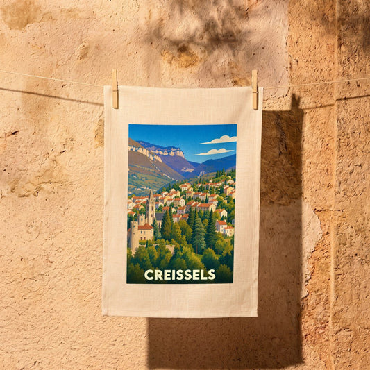Torchon souvenir de la ville de Creissels avec une illustration stylisée d'un village de montagne.