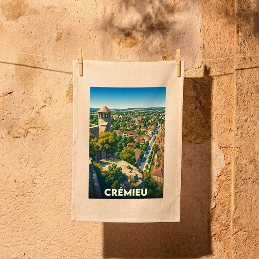 Torchon souvenir de la ville de Crémieu avec une illustration panoramique stylisée.