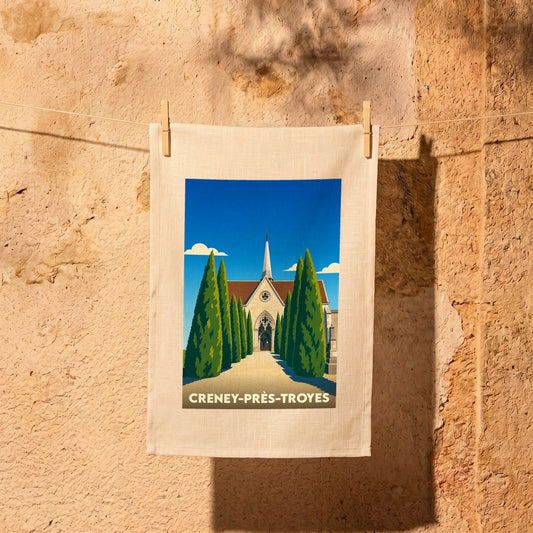 Torchon souvenir de la ville de Creney-près-Troyes avec une illustration stylisée de son église.