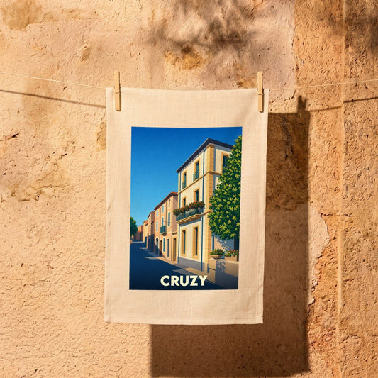 Torchon souvenir de la ville de Cruzy avec une illustration stylisée de ses rues ensoleillées.