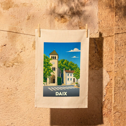 Torchon souvenir de la ville de Daix illustrant son église et ses maisons sous un ciel bleu.