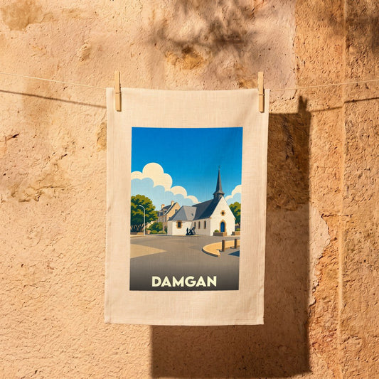 Torchon souvenir de la ville de Damgan avec une illustration stylisée de son église sous un ciel bleu.