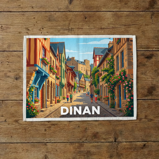 Torchon souvenir de la ville de Dinan avec une illustration stylisée d'une rue pittoresque.