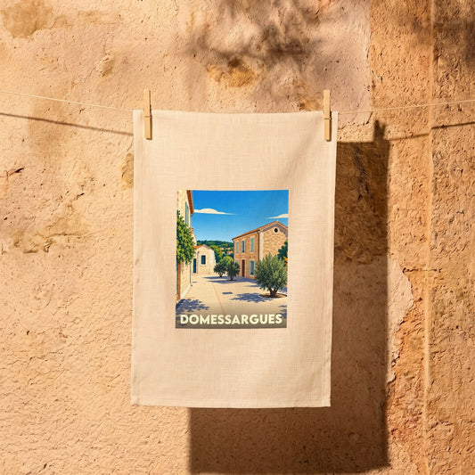Torchon souvenir de la ville de Domessargues avec une illustration stylisée d'un village provençal.