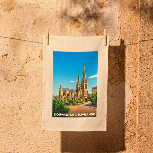 Torchon souvenir de la ville de Douvres-la-Délivrande avec une illustration stylisée de sa basilique.