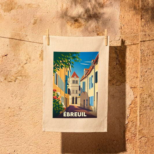 Torchon souvenir de la ville d'Ébreuil avec une illustration stylisée d'une ruelle ensoleillée menant au clocher.
