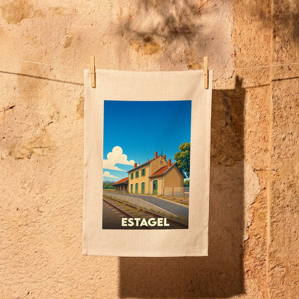 Torchon souvenir de la ville d'Estagel avec une illustration stylisée d'une gare sous un ciel bleu.
