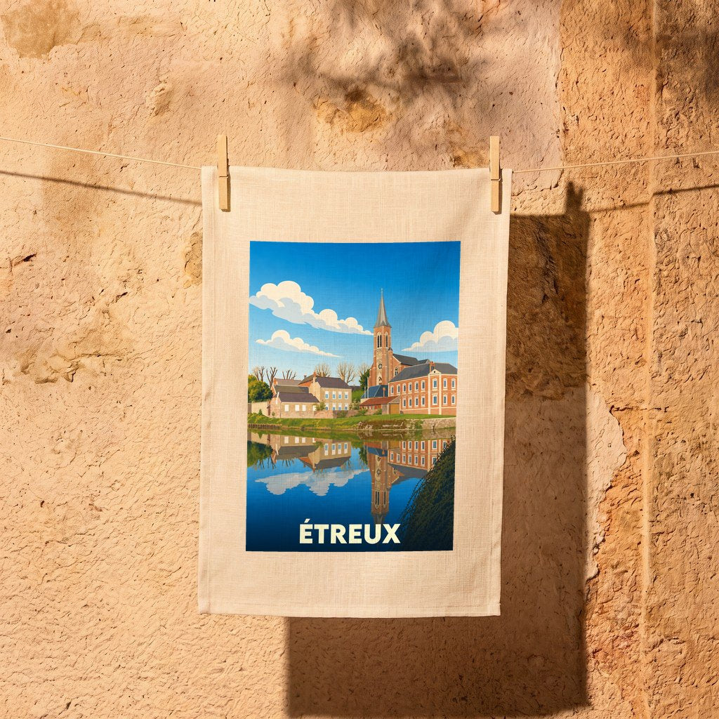 Torchon souvenir de la ville d'Étreux avec une illustration stylisée d'un paysage urbain au bord de l'eau.