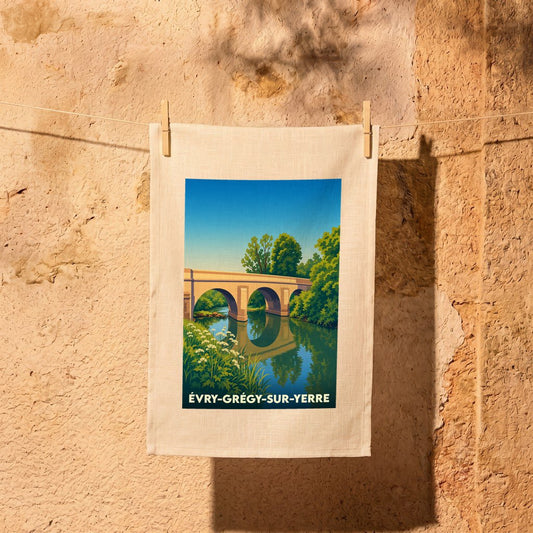 Torchon souvenir de la ville d'Évry-Grégy-sur-Yerre avec une illustration stylisée d'un pont en pierre.