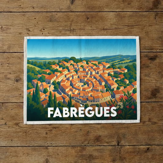 Torchon souvenir de la ville de Fabrègues illustré d'une vue aérienne stylisée du village circulaire.