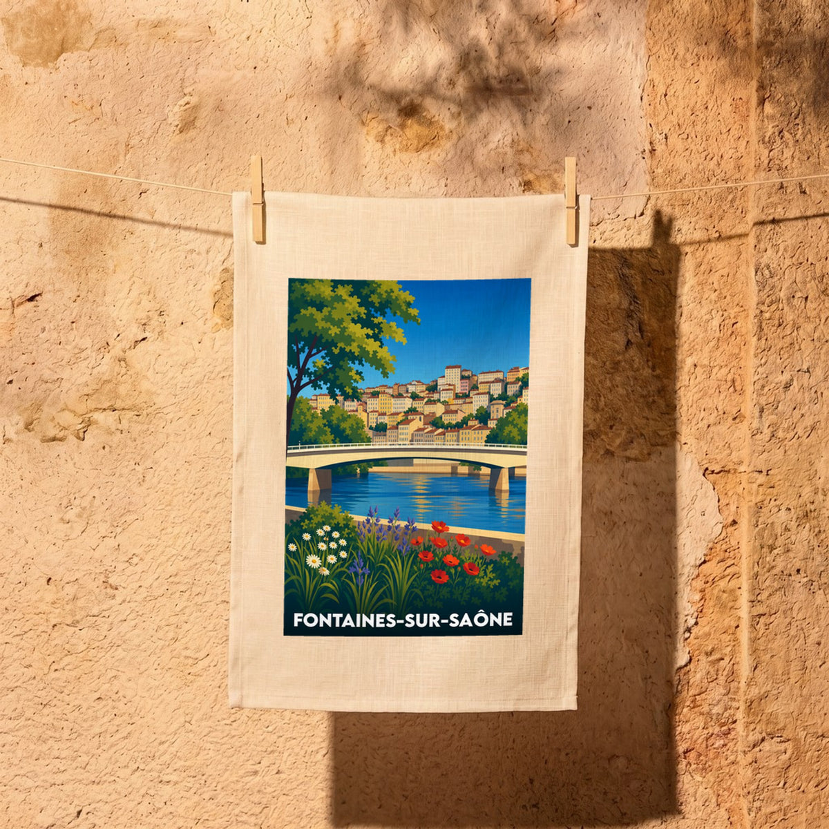 Torchon souvenir de Fontaines-sur-Saône avec une illustration stylisée de la ville et de son pont.