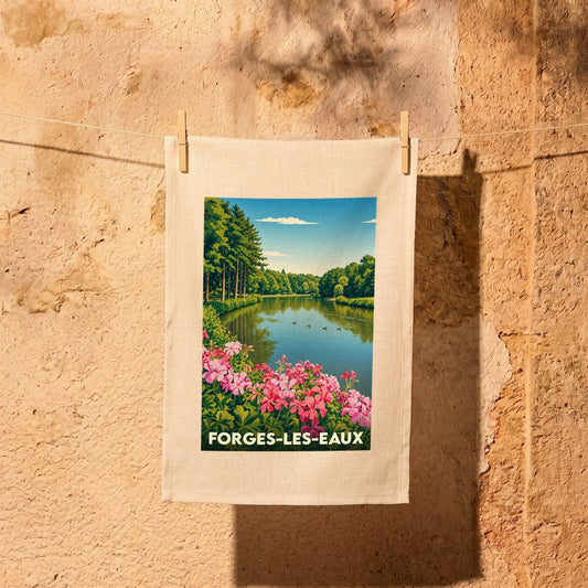 Torchon souvenir de la ville de Forges-les-Eaux illustré d'un paysage de lac fleuri.