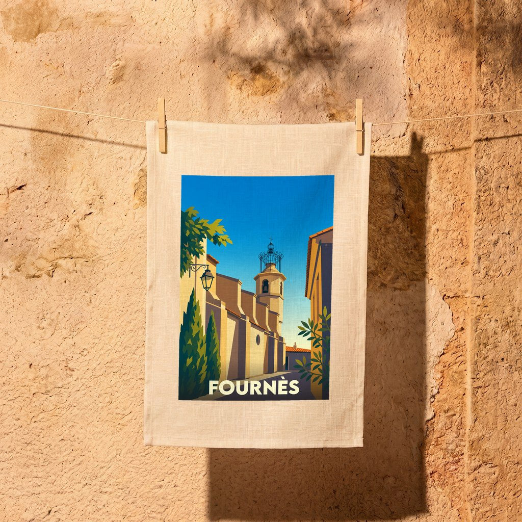 Torchon souvenir de la ville de Fournès avec une illustration stylisée d'une rue ensoleillée et de son clocher.