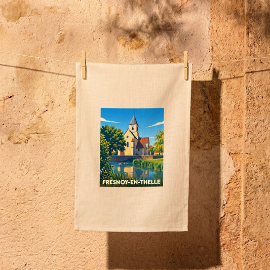 Torchon souvenir de la ville de Fresnoy-en-Thelle avec une illustration stylisée de son église au bord de l'eau.