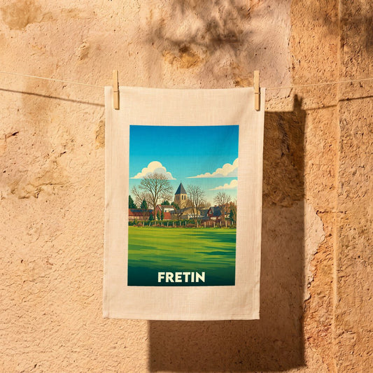 Torchon souvenir de la ville de Fretin illustré d'un paysage champêtre au style rétro.