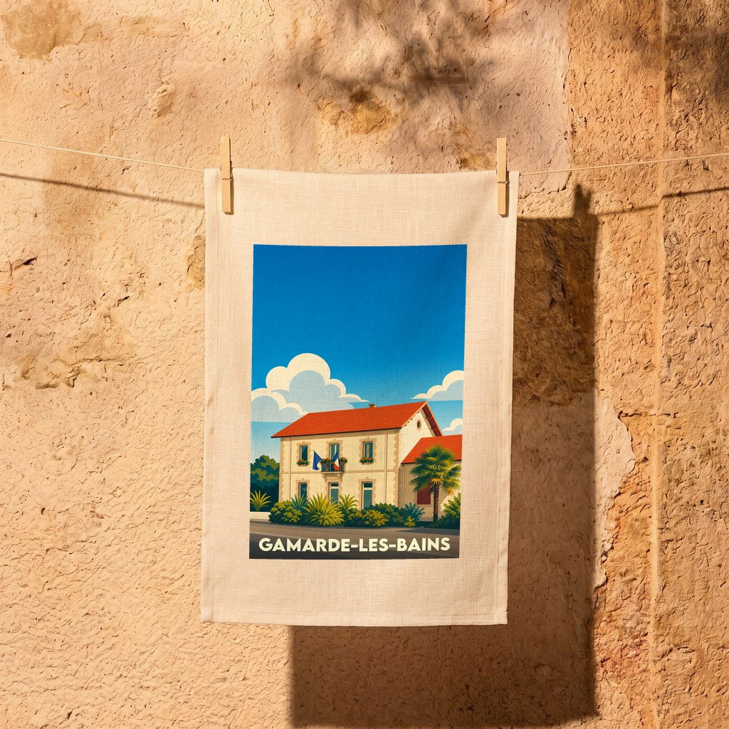 Torchon souvenir de la ville de Gamarde-les-Bains avec une illustration stylisée d'une bâtisse landaise sous un ciel bleu.