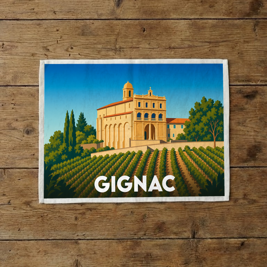 Torchon souvenir de la ville de Gignac orné d'une illustration stylisée représentant une abbaye surplombant un vignoble.