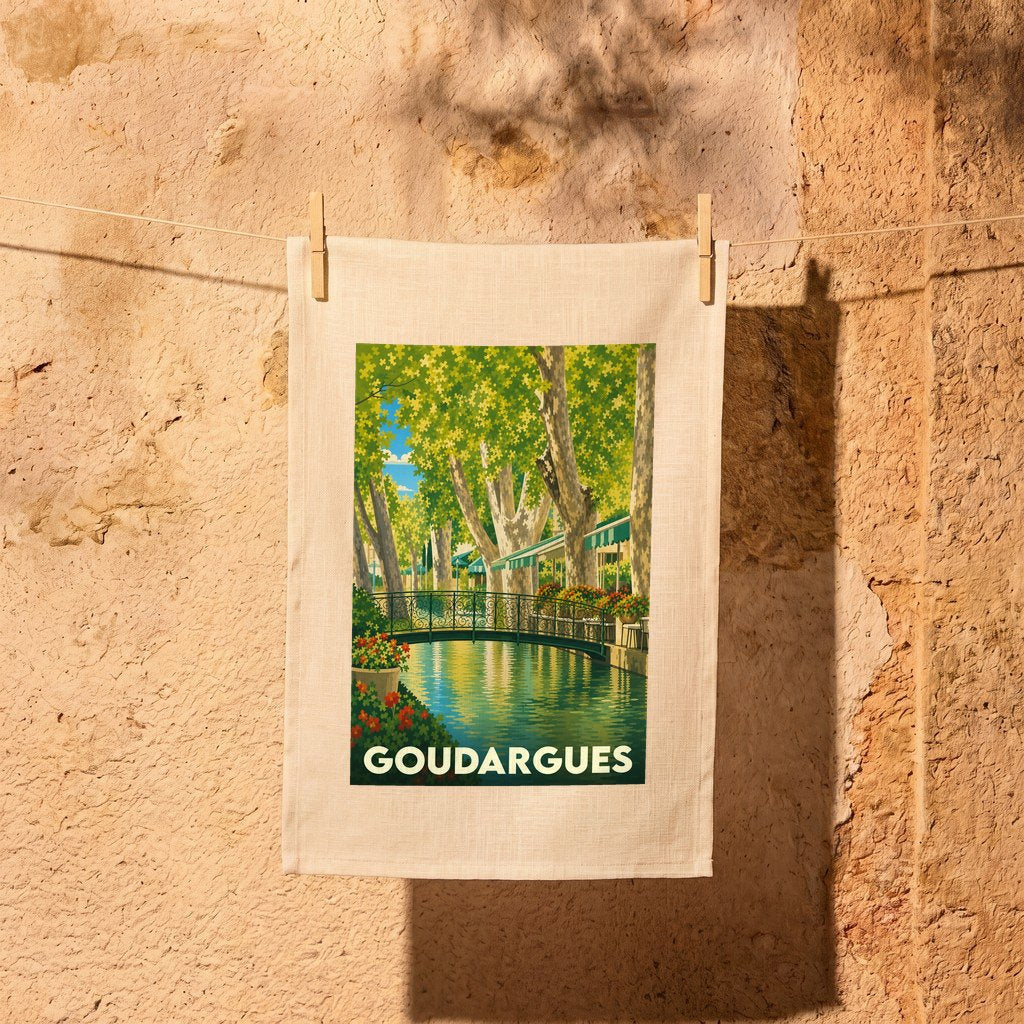 Torchon souvenir de la ville de Goudargues illustré d'une scène de canal arboré.
