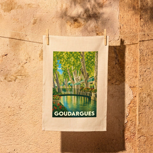 Torchon souvenir de la ville de Goudargues illustré d'une scène de canal arboré.