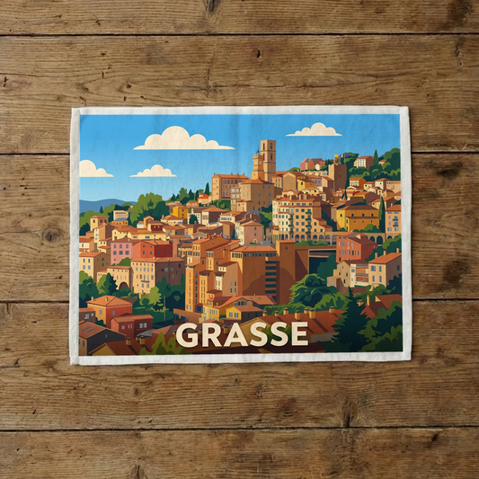 Torchon souvenir de la ville de Grasse avec une illustration stylisée et colorée de ses bâtiments provençaux.