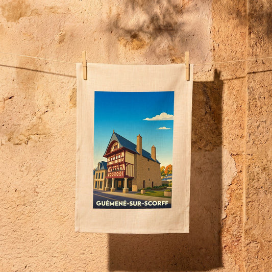 Torchon souvenir de la ville de Guémené-sur-Scorff avec une illustration stylisée d'une maison à colombages.