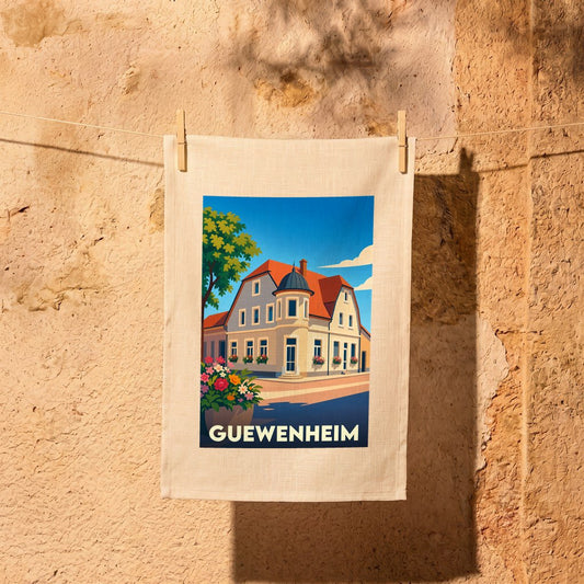 Torchon souvenir de la ville de Guewenheim orné d'une illustration stylisée représentant un bâtiment traditionnel alsacien.