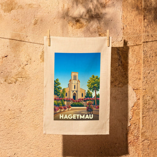 Torchon souvenir de la ville de Hagetmau avec une illustration stylisée de son église et de ses jardins fleuris.