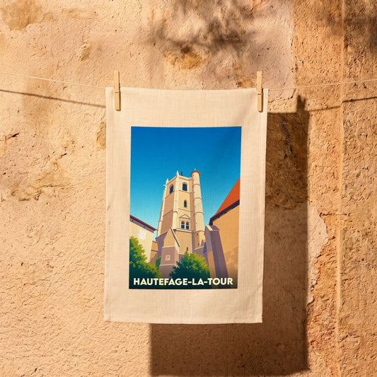 Torchon souvenir de Hautefage-la-Tour avec une illustration stylisée de sa tour médiévale sous un ciel bleu.