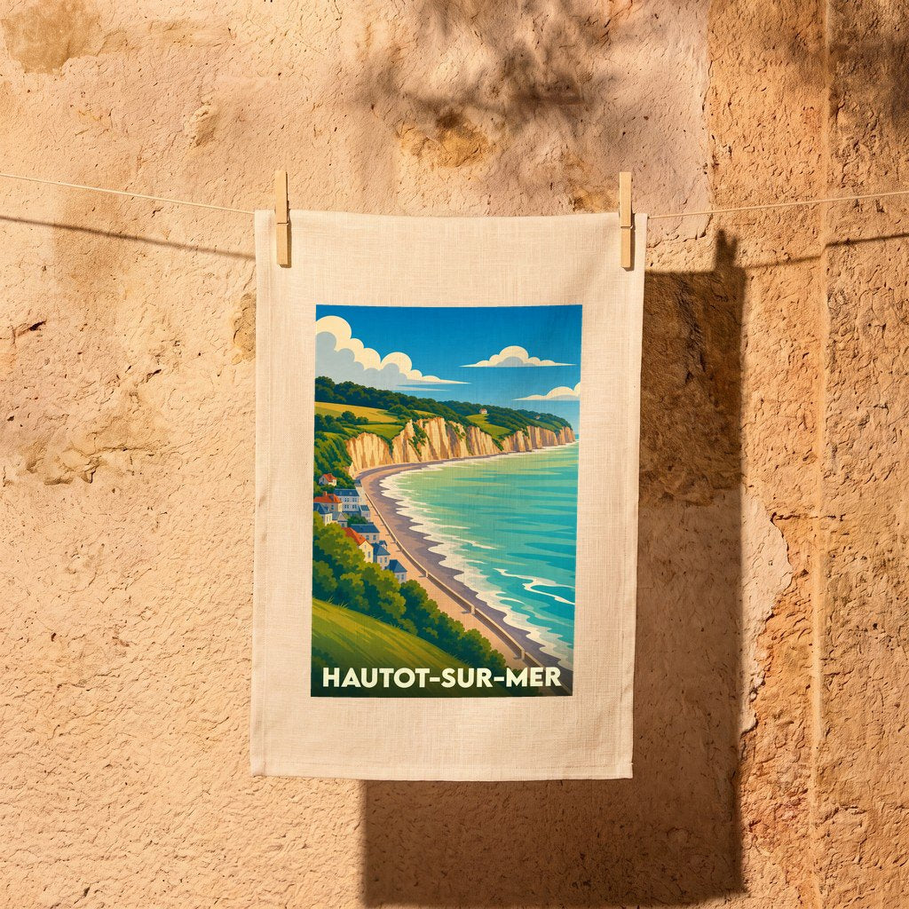 Torchon souvenir de la ville de Hautot-sur-Mer illustrant un paysage côtier avec falaises et plage.