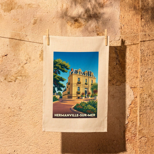 Torchon souvenir de la ville de Hermanville-sur-Mer avec une illustration stylisée d'une villa balnéaire.