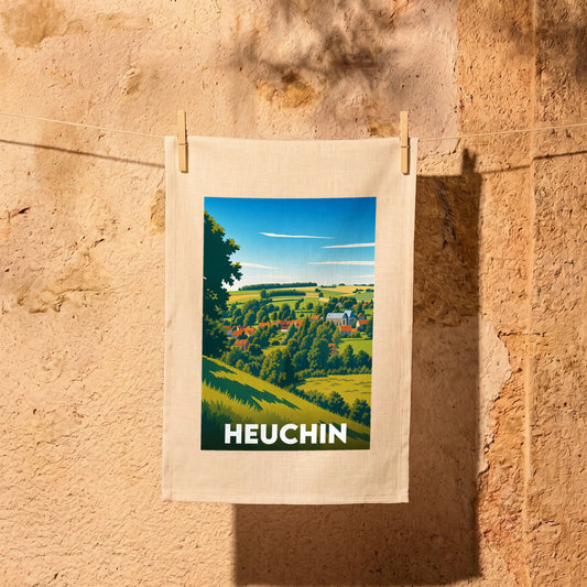 Torchon souvenir de la ville de Heuchin avec une illustration de paysage champêtre stylisée.
