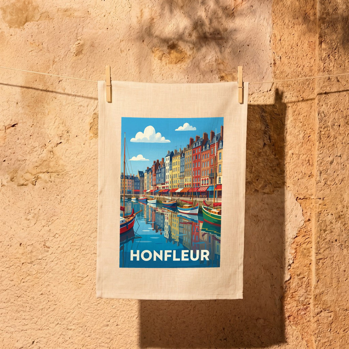 Torchon souvenir de la ville de Honfleur avec une illustration stylisée de son port.