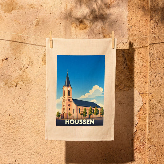 Torchon souvenir de la ville de Houssen avec une illustration stylisée de son église sous un ciel bleu.