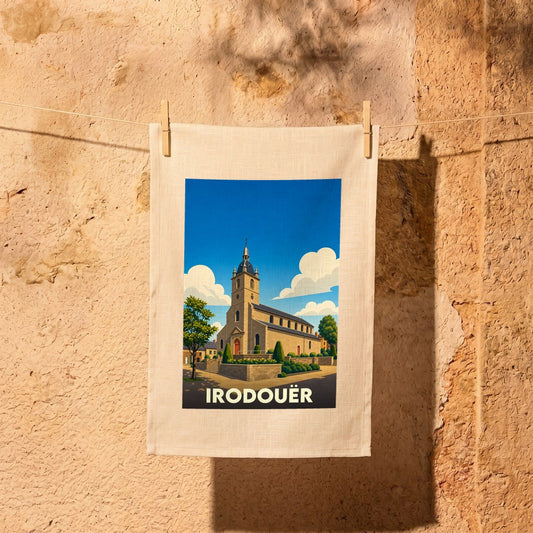 Torchon souvenir de la ville d'Irodouër avec une illustration stylisée de son église sous un ciel bleu.