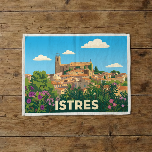 Torchon souvenir de la ville d'Istres avec une illustration stylisée de son clocher et de ses toits.