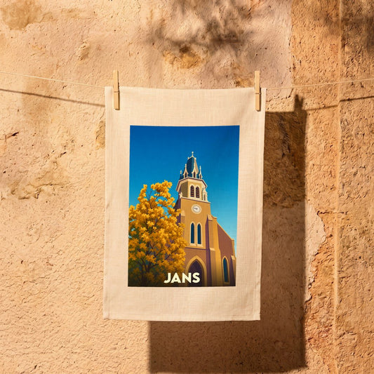 Torchon souvenir de la ville de Jans avec une illustration stylisée de son église et d'un arbre automnal.
