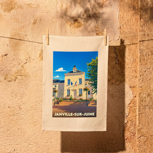 Torchon souvenir de la ville de Janville-sur-Juine illustré par une vue stylisée de la mairie sous un ciel bleu.