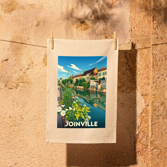 Torchon souvenir de la ville de Joinville avec une illustration stylisée d'un canal fleuri.