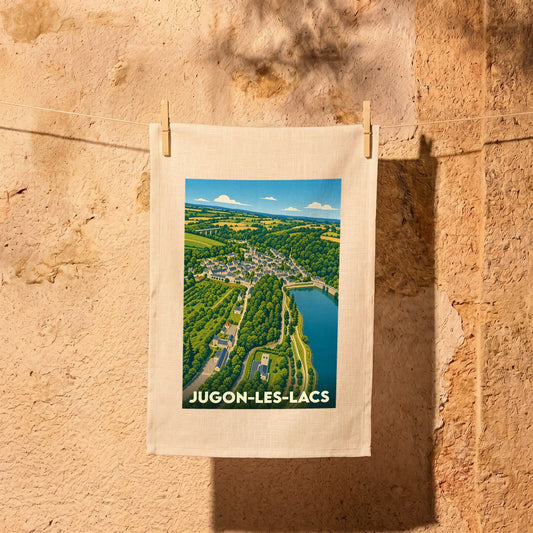 Torchon souvenir de la ville de Jugon-les-Lacs avec une illustration de style affiche vintage représentant un paysage de vallée.