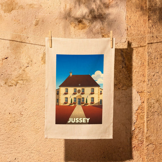 Torchon souvenir de la ville de Jussey avec une illustration stylisée d'une bâtisse traditionnelle.
