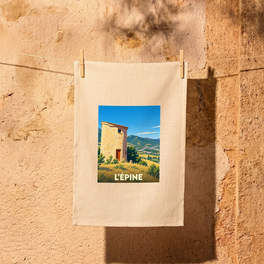 Torchon souvenir de la ville de L'Épine illustré d'un moulin provençal dans un paysage montagneux.